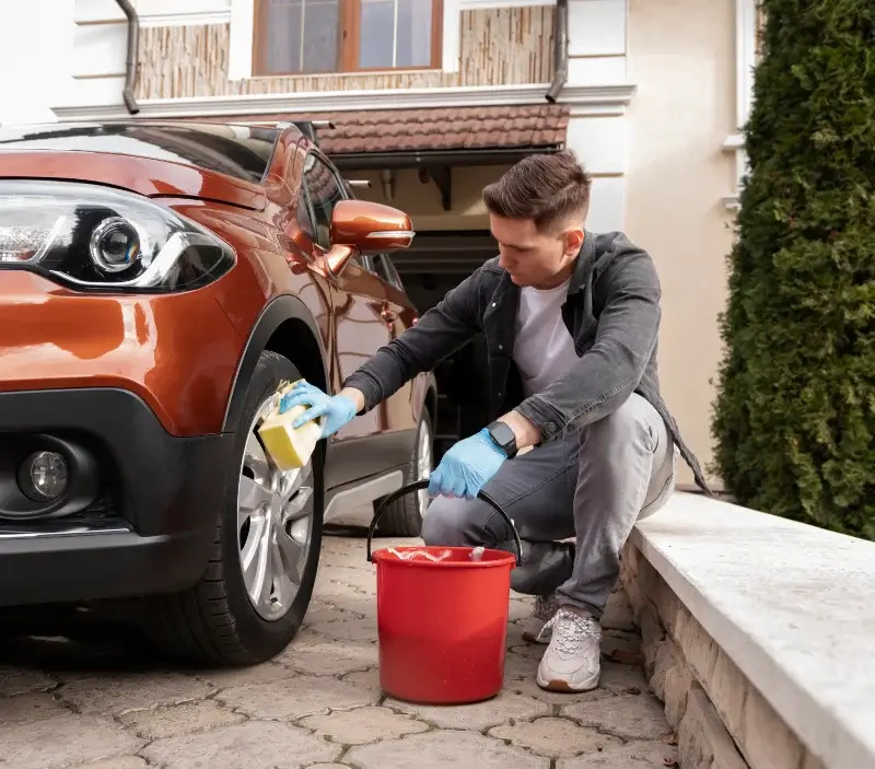 Lavage auto à domicile Les Moutiers-en-Cinglais : professionnel intervenant sur un véhicule